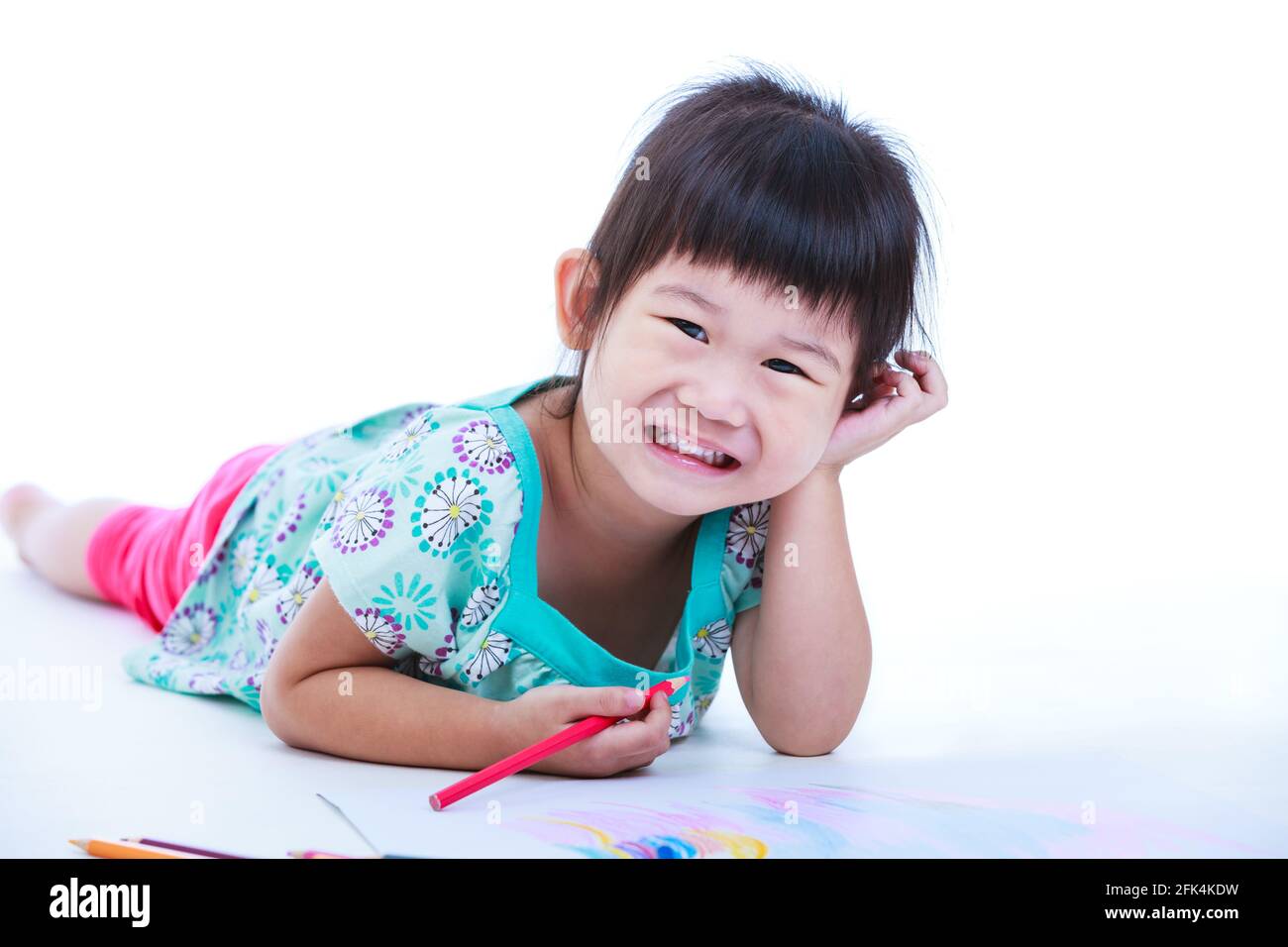 Pretty asian girl lie on the floor looking at camera and smiling. Concepts of creativity and education, strengthen the imagination of child. Studio sh Stock Photo