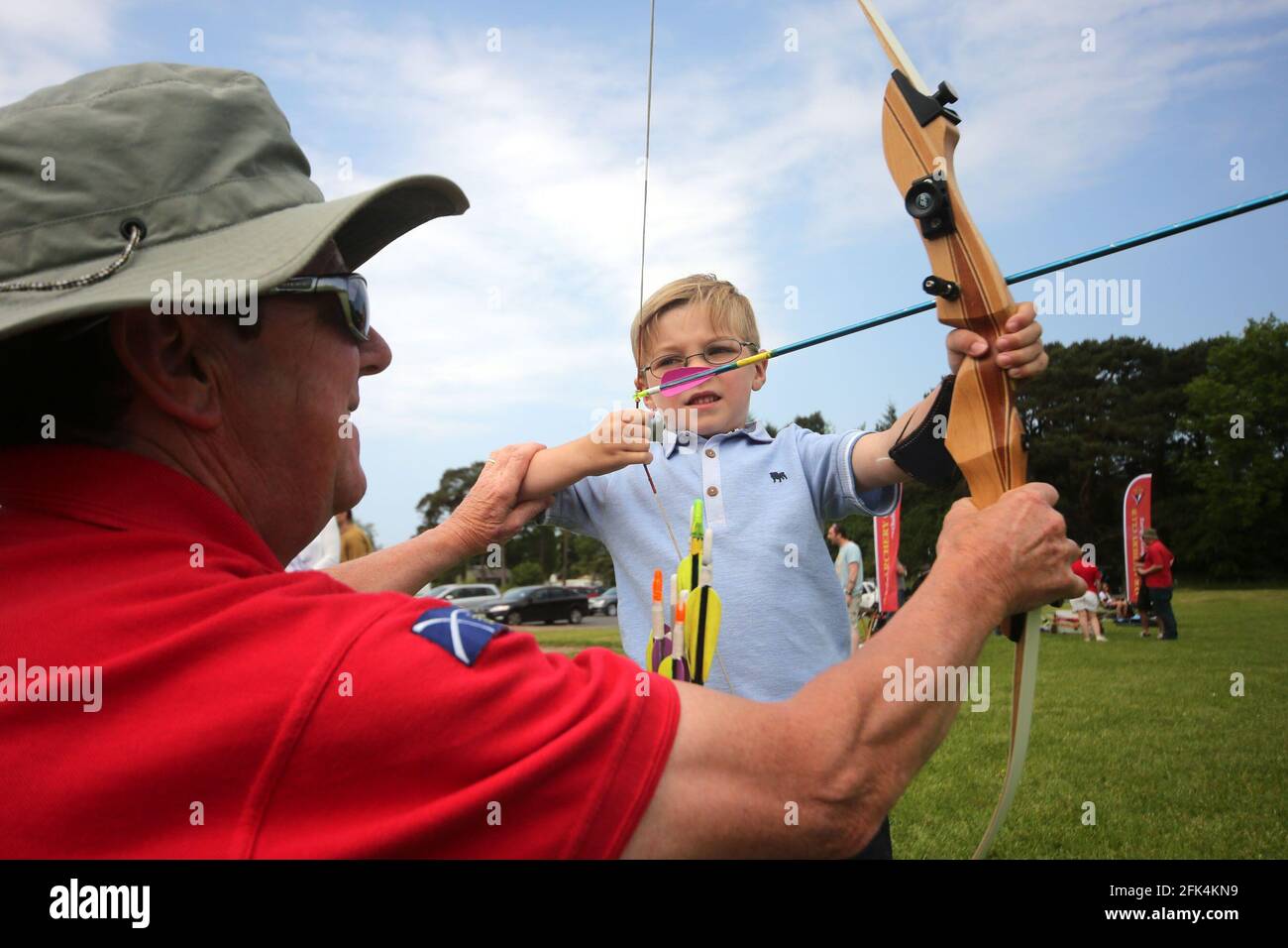 Ayr Archery Club held an open day 'Come and try Archery ' at the J.Mowatt playing fields Doonside, Ayr 5yr old Lewis Flynn receives instruction from Willie Roney Stock Photo
