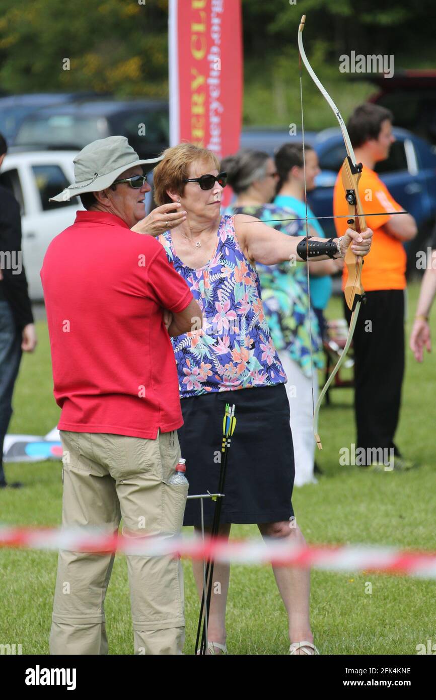 Ayr Archery Club held an open day 'Come and try Archery ' at the J.Mowatt playing fields Doonside, Ayr Moira Jones releases her arrow under the watchful eye of  Willie Roney Stock Photo