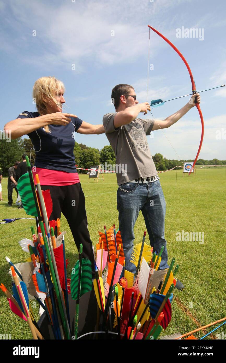 Ayr Archery Club held an open day 'Come and try Archery ' at the J.Mowatt playing fields Doonside, Ayr Helen Cresswell a coach with Ayr Archery club shows David Clachrie from Ayr how to use a bow Stock Photo