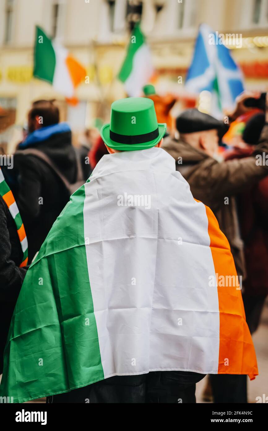 Behind of man in green Irish hat with National Flag of Ireland on his back  close-up on background of crowd people in city street. Saint Patrick day ho  Stock Photo - Alamy