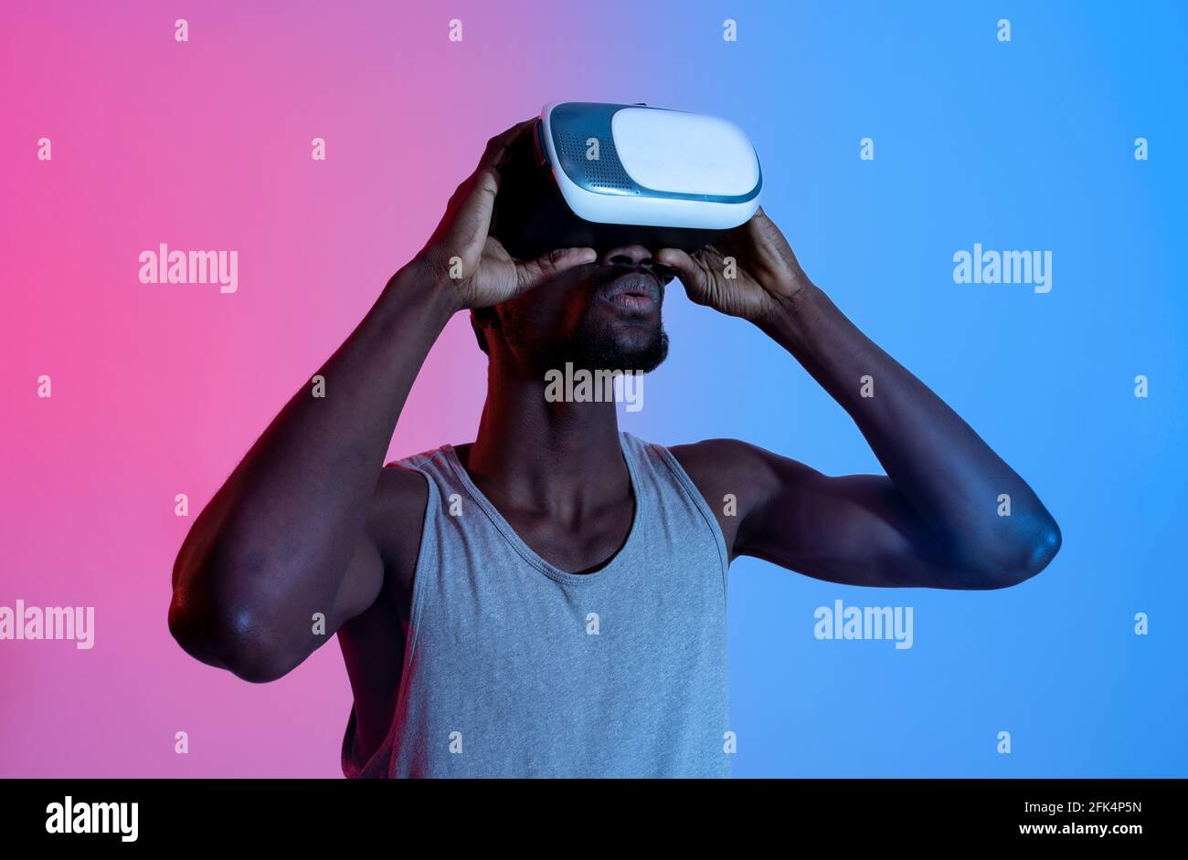 Athletic black guy wearing VR headset, doing virtual workout in ...