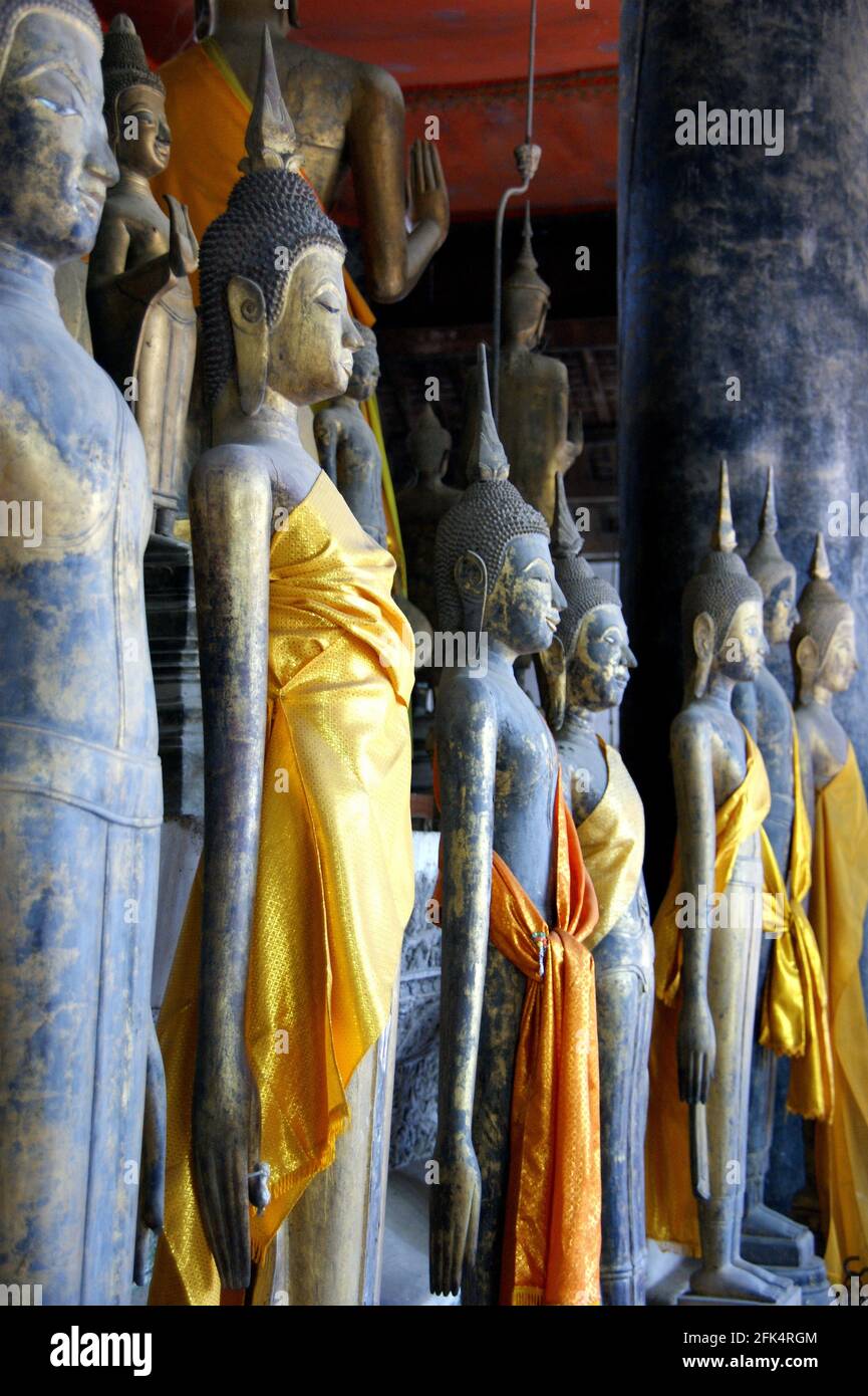 Statues dressed in golden robes call for rain in a Laotian temple. Stock Photo