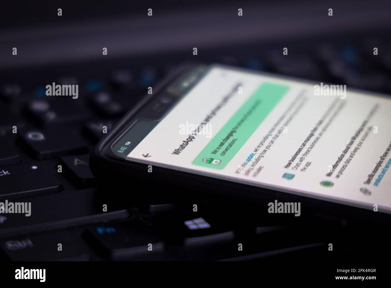 WhatsApp Terms of Service on a smartphone against a PC computer. Stock Photo