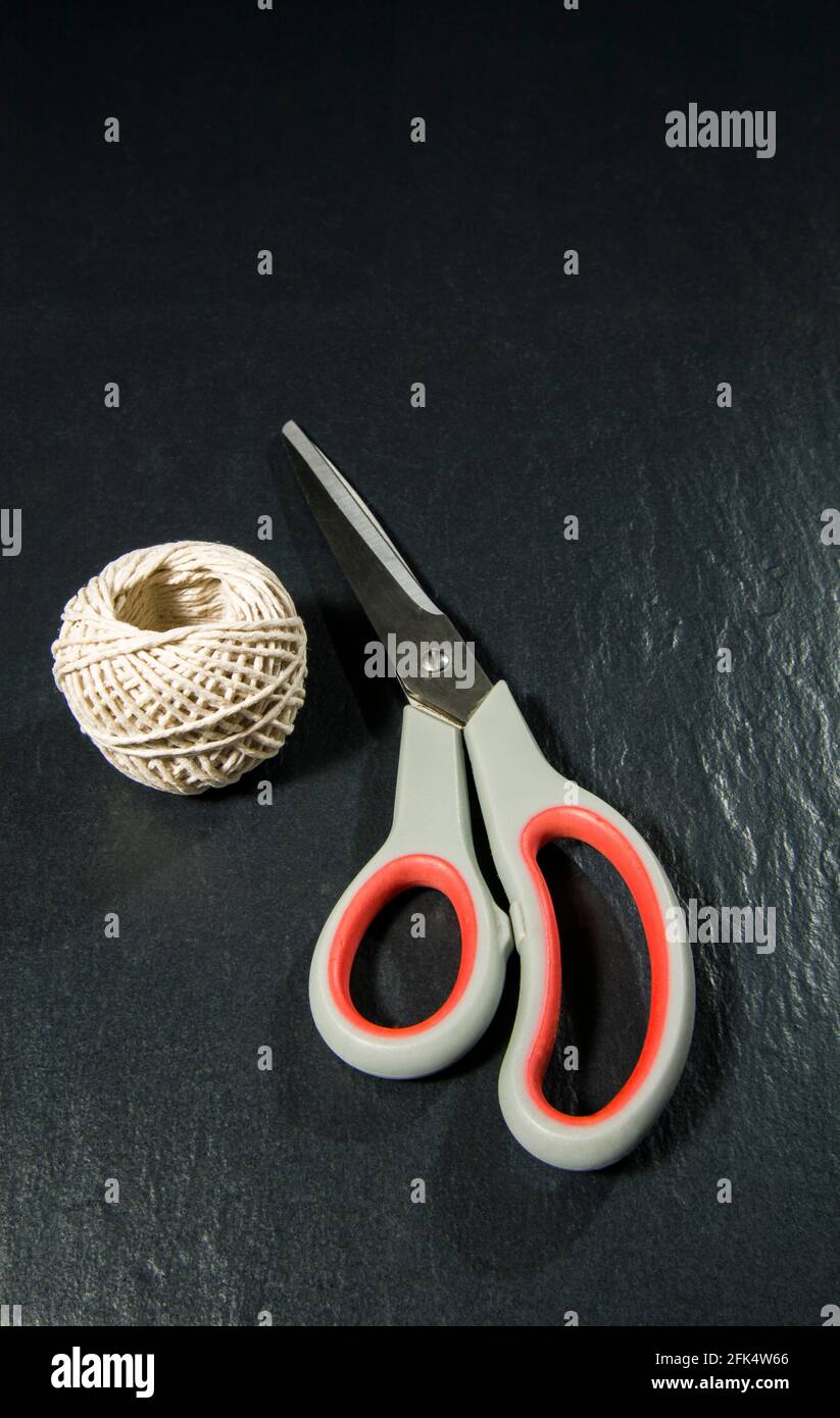 a ball of string and a scissors Stock Photo