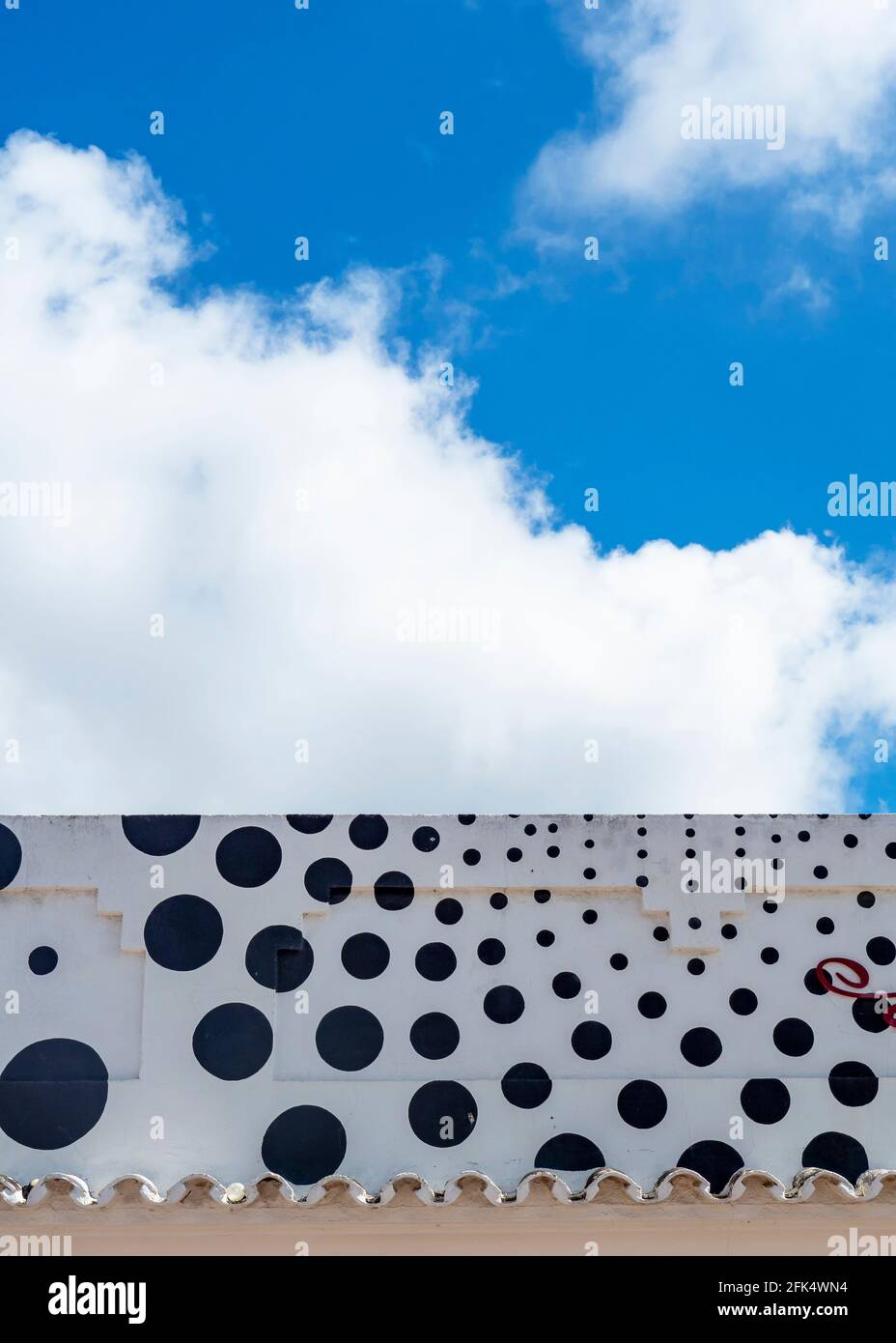 Polka-dotted facade with blue sky and clouds Stock Photo