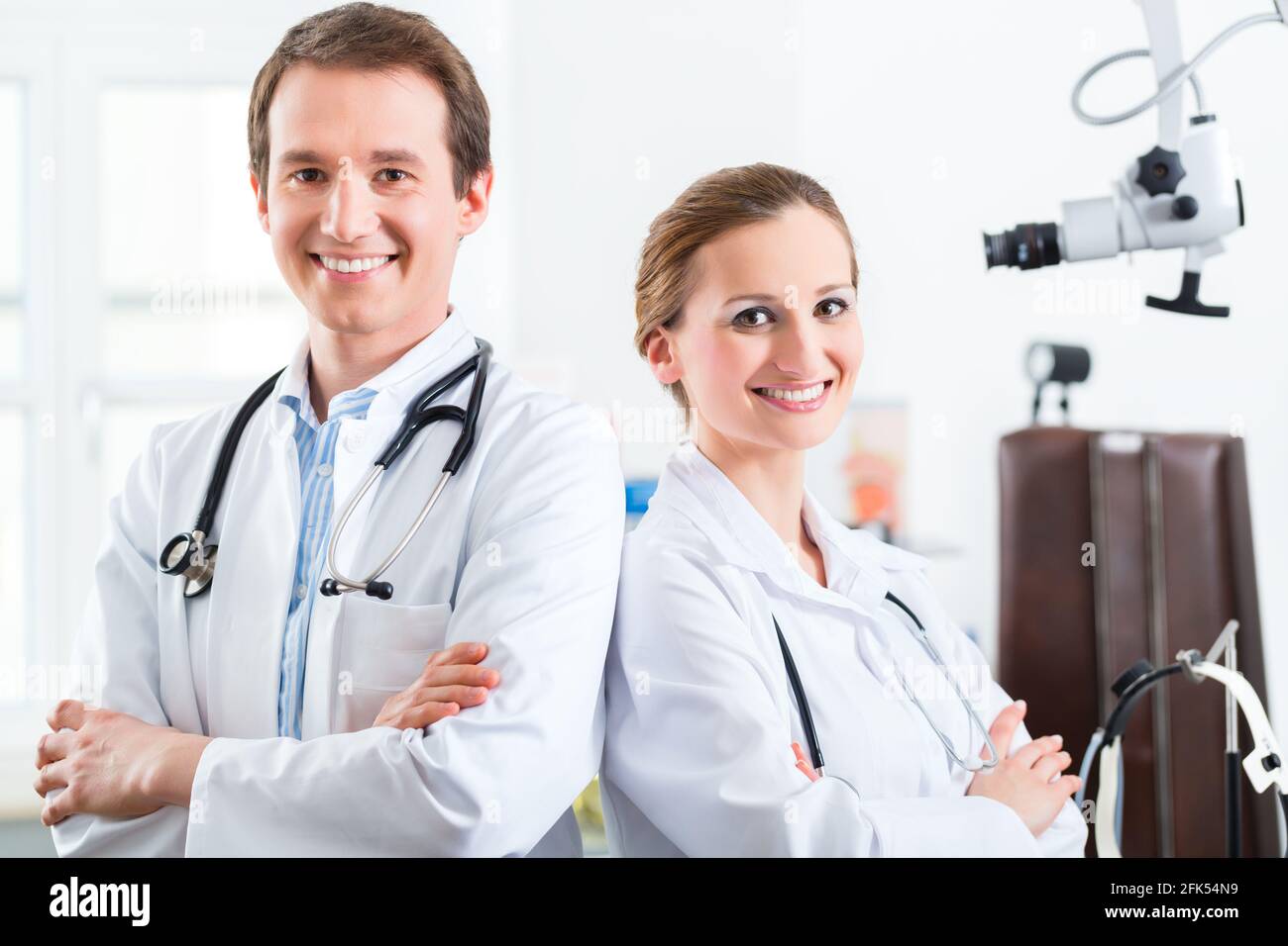 Doctors - male and female, standing with a stethoscope in clinic or ...