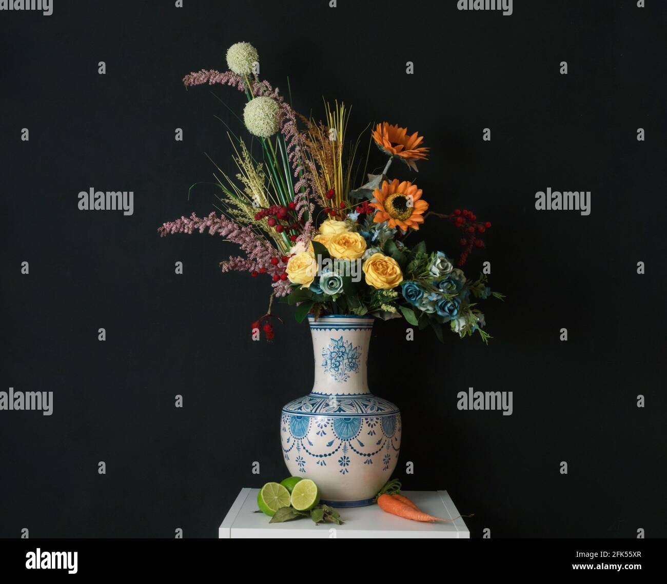 Ceramic vase with coloured flowers on a black background. Still life of flowers Stock Photo