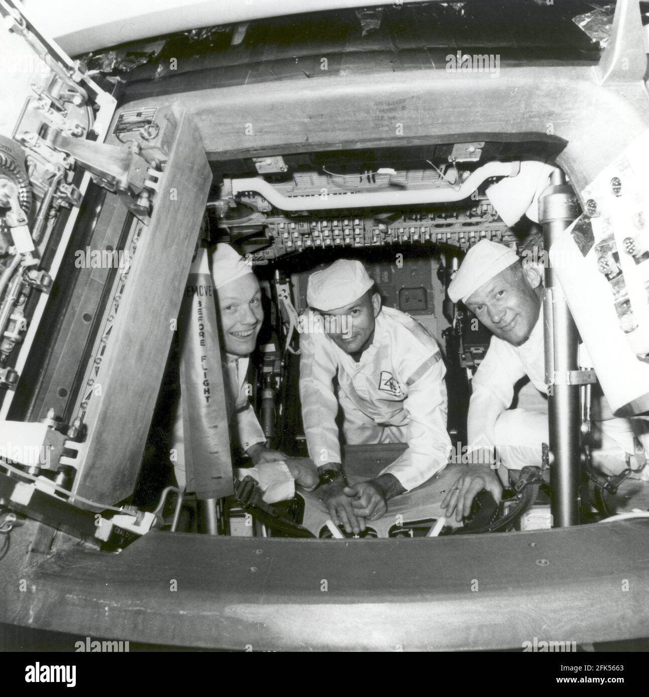 Cape Canaveral, FL - (FILE) -- The Apollo 11 crew conducting a crew compartment fit and functional check, of the equipment and storage locations, in their command module on June 10, 1969. Peering from the hatch are from left, Neil Armstrong, commander; Michael Collins, command module pilot; and Buzz Aldrin, lunar module pilot. Armstrong and Aldrin later conducted a similar check aboard the lunar module, which carried them down to the lunar surface on July 20, 1969.Credit: NASA via CNP /MediaPunch Stock Photo