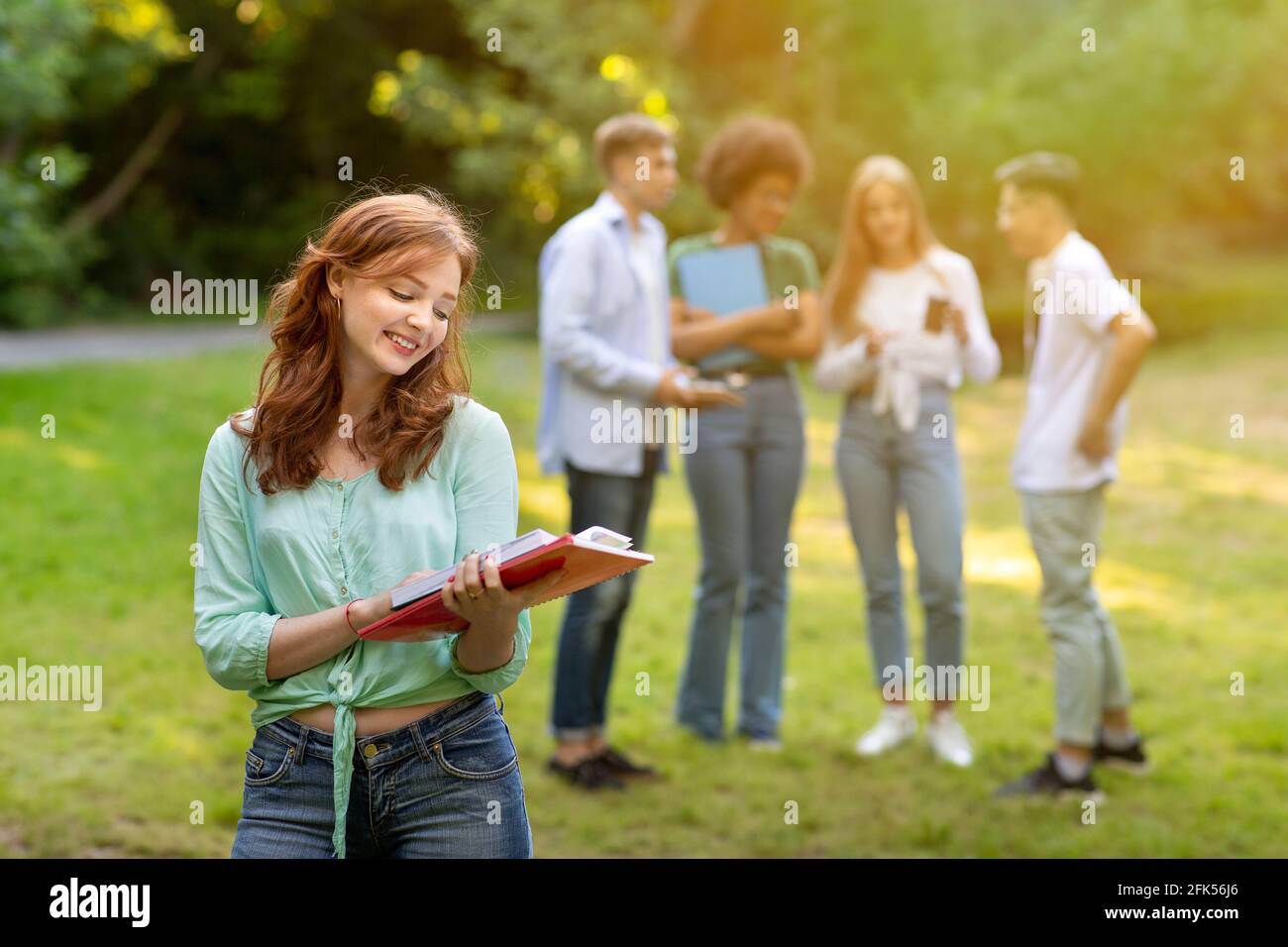 Student Exchange Programs. Beautiful College Girl Preparing For Lessons Outdoors With Notepad Stock Photo