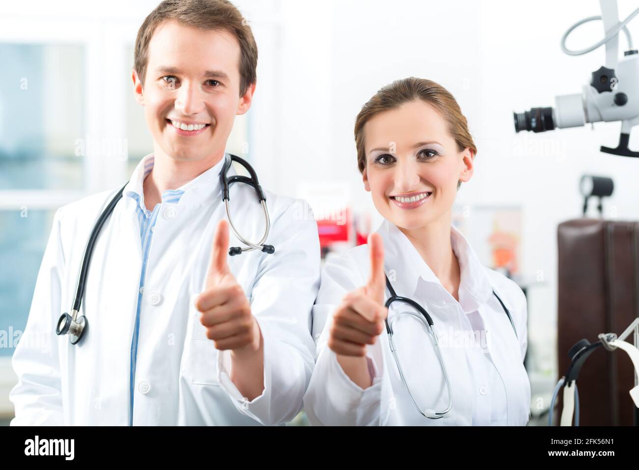 Doctors - male and female, standing with a stethoscope in clinic or ...