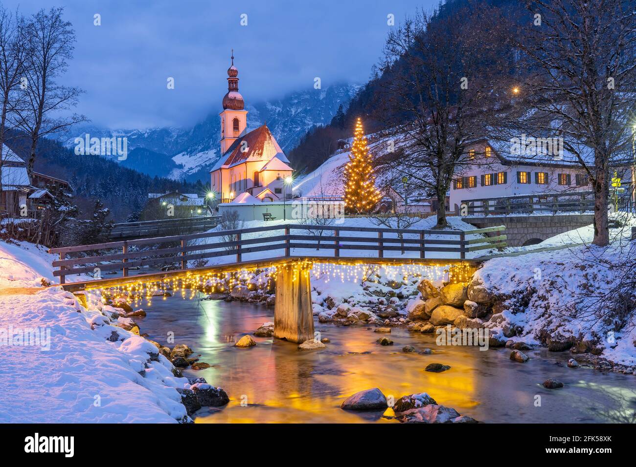 das tiefverschneite Ramsauer Kircherl vor der imposanten Kulisse der Reiter Alpe in der stimmungsvollen Zeit der Weihnacht Stock Photo