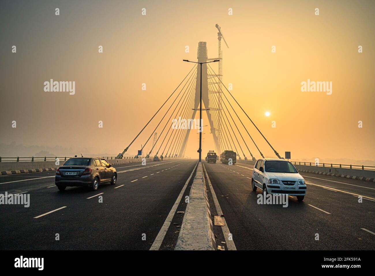 signature bridge is a cantilever spar cable stayed bridge which spans the yamuna river in delhi,with beautiful sun rise. Stock Photo