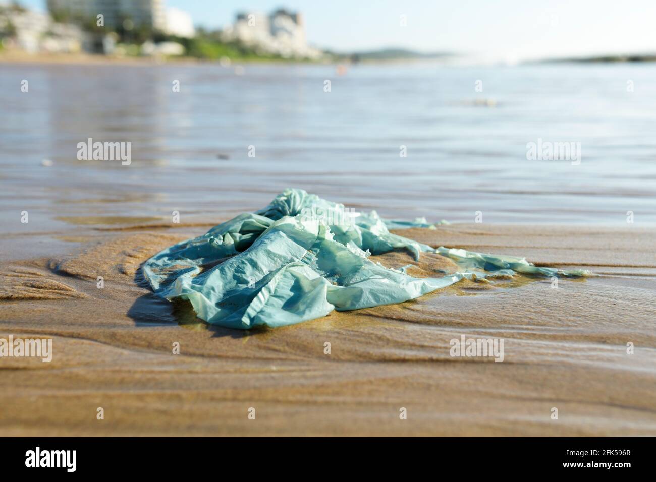 Plastic shopping bag pollution, waste on beautiful beach, Umhlanga Rocks waterfront, Durban, South Africa, close up, packaging object, single use Stock Photo