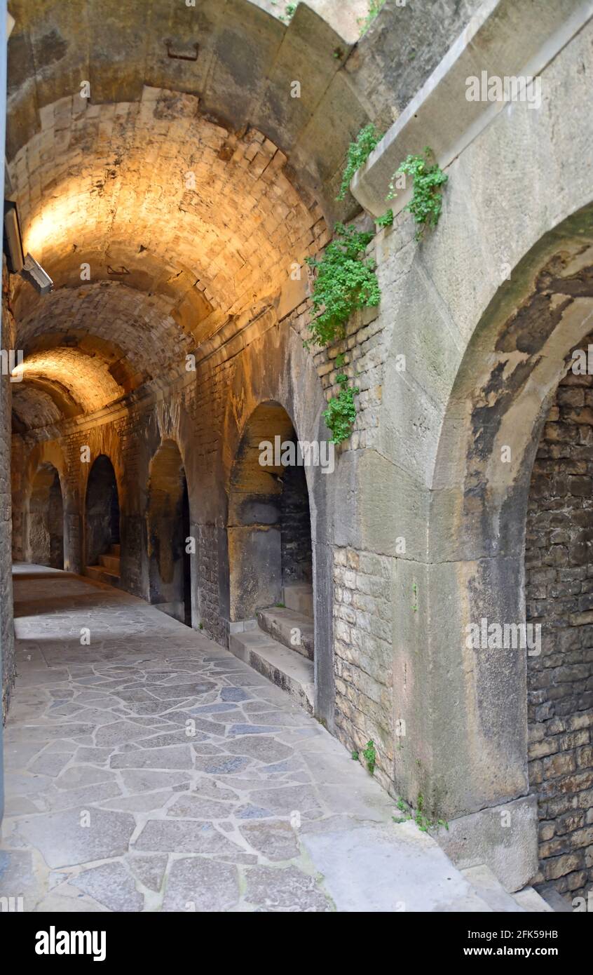Vaulted internal corridor of an Ancient Roman Amphitheatre at Nimes in the South of France with steps leading to the seats. One of the best preserved Stock Photo