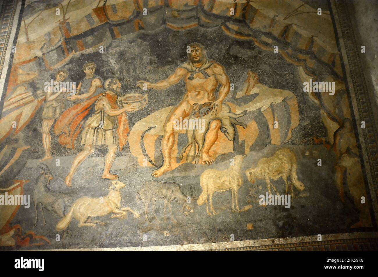 Ancient Roman mosaic of Odysseus getting the Cyclops Giant Polyphemus drunk in his cave. From Book IX of the Odyssey. In the UNESCO listed Ancient Rom Stock Photo