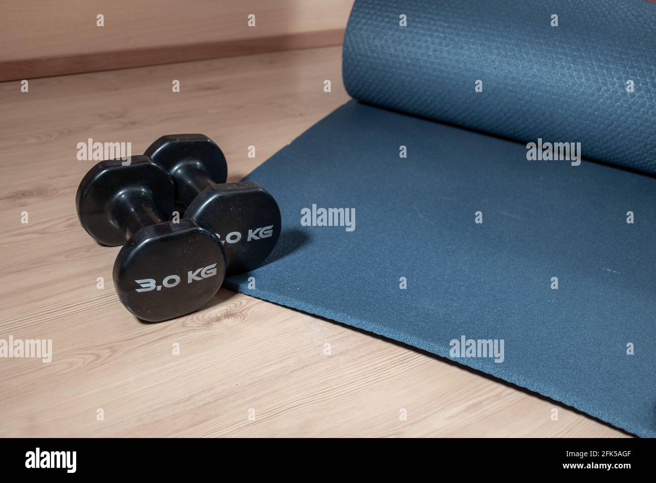 Closeup shot of 3 kg dumbbells and home training mat Stock Photo