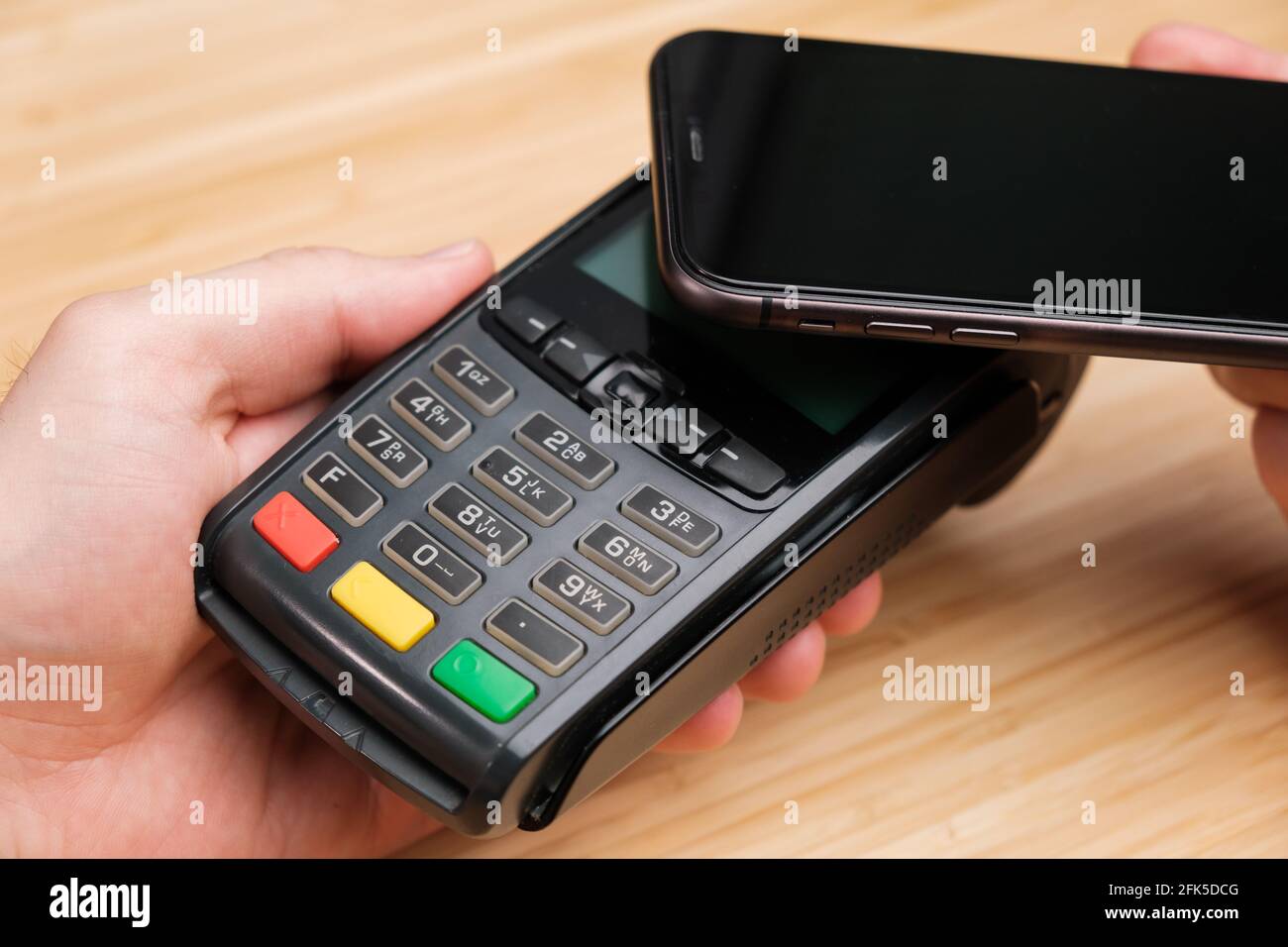 Man uses wireless terminal contactless payment with smartphone Stock Photo