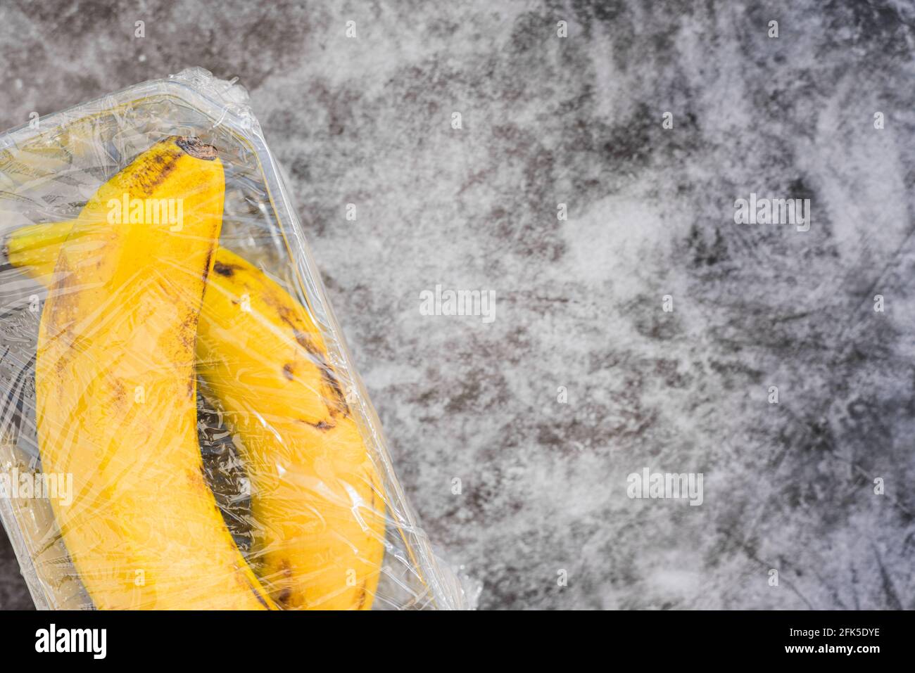 Bananas with natural peel wrapped in pointless plastic packaging Stock Photo Alamy