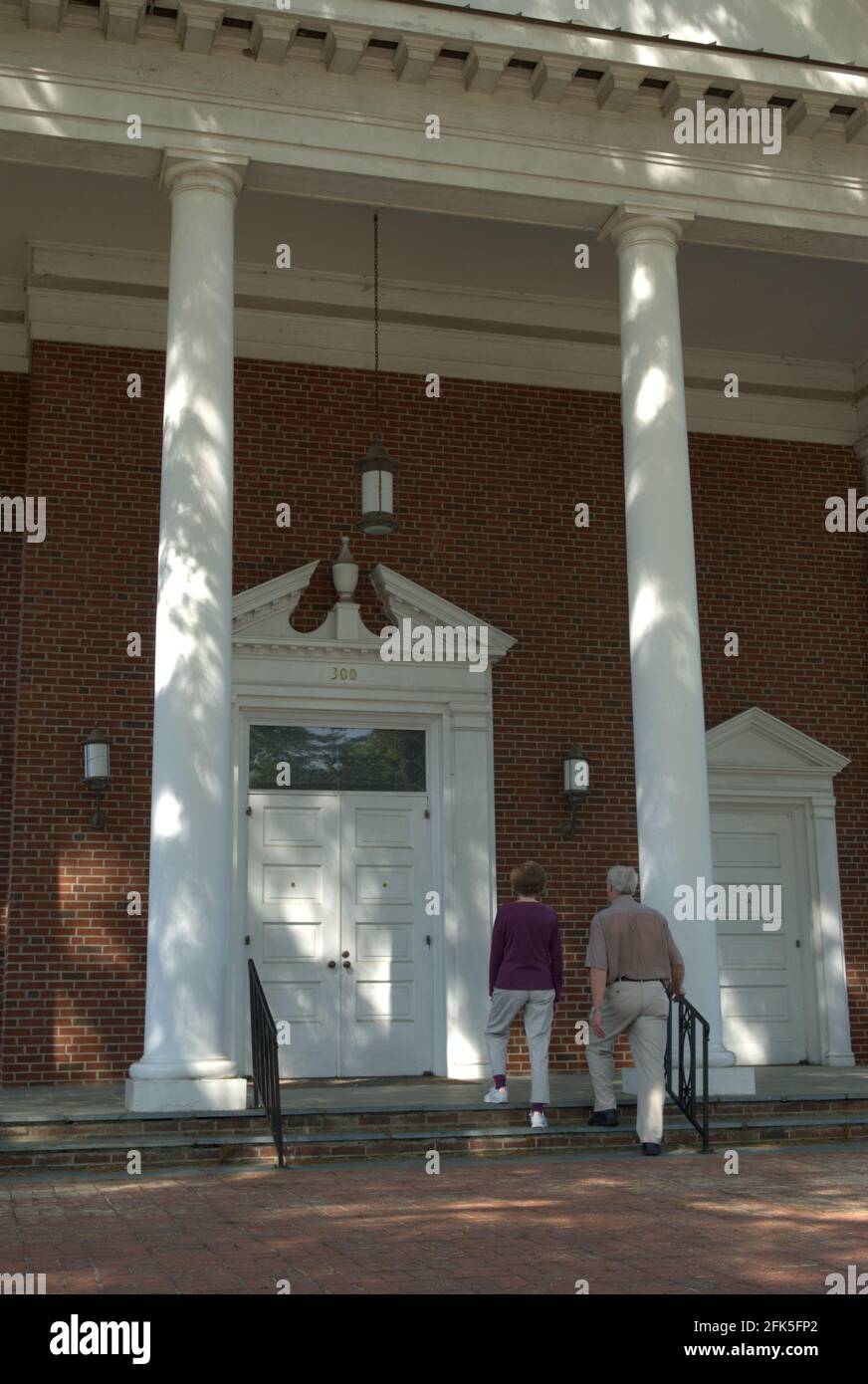 Caucasian senior couple (age 60-70) walking up steps at First Baptist Church, Lancaster, South Carolina, USA. Stock Photo