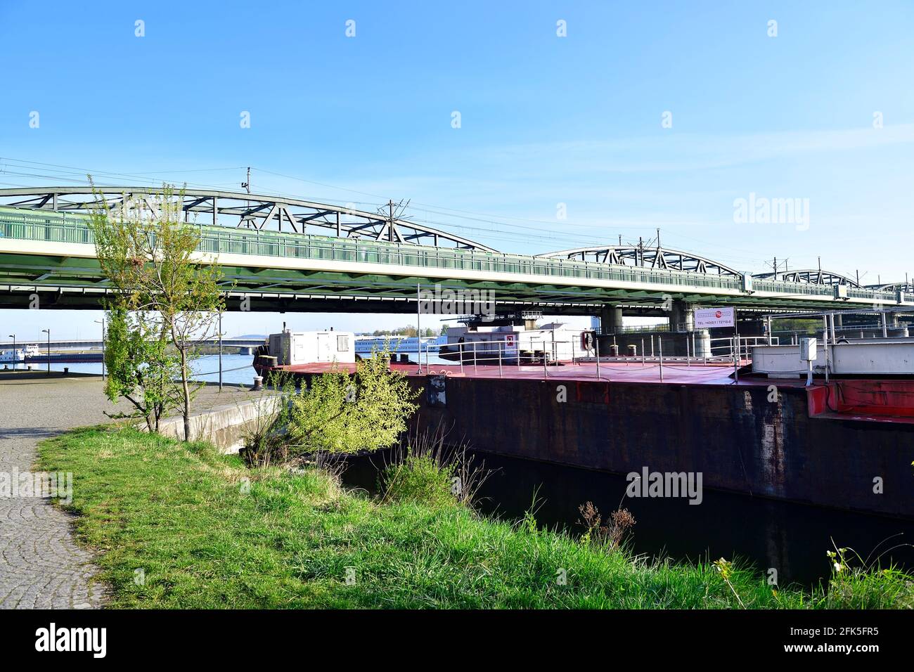 Vienna, Austria. Cargo ship on the Danube with the northern railway ...