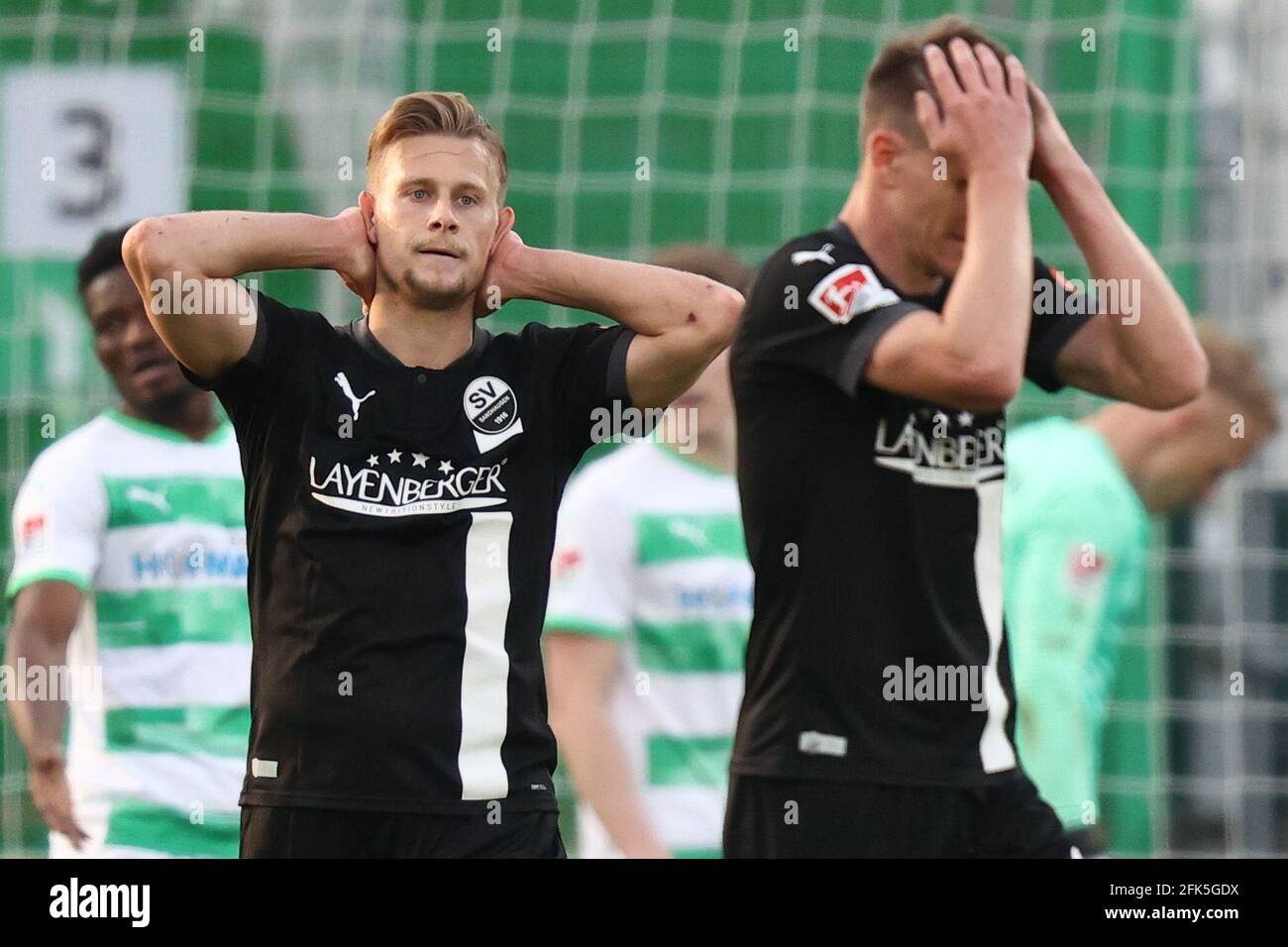 28 April 2021, Bavaria, Fürth: Football: 2. Bundesliga, SpVgg Greuther Fürth - SV Sandhausen, Matchday 28, at Sportpark Ronhof Thomas Sommer. Kevin Behrens (l) and Emanuel Taffertshofer of SV Sandhausen react to the match delay. Photo: Daniel Karmann/dpa - IMPORTANT NOTE: In accordance with the regulations of the DFL Deutsche Fußball Liga and/or the DFB Deutscher Fußball-Bund, it is prohibited to use or have used photographs taken in the stadium and/or of the match in the form of sequence pictures and/or video-like photo series. Stock Photo