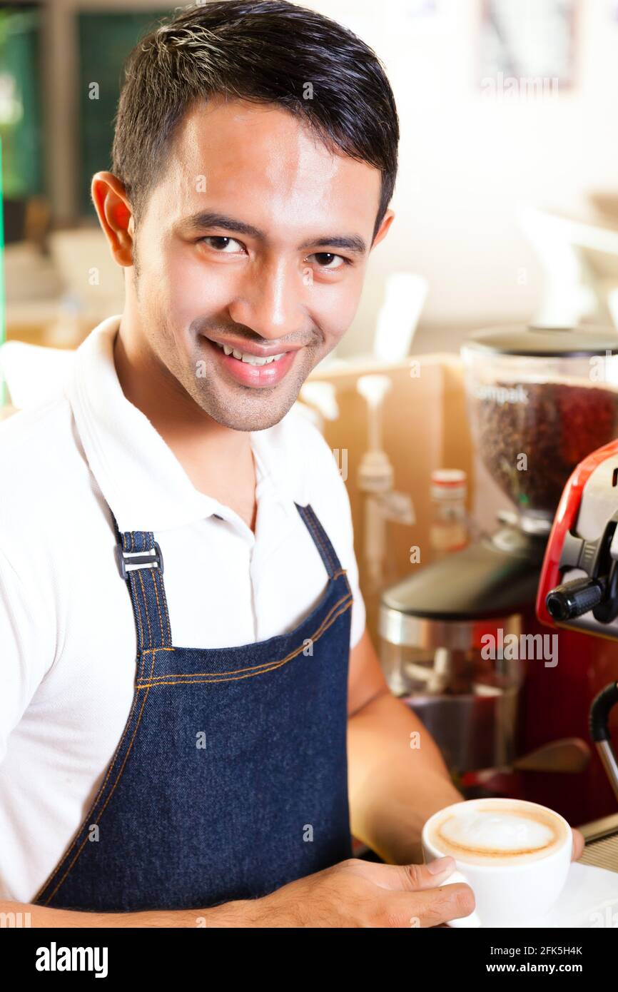 asian barista presents coffee in his shop Stock Photo Alamy