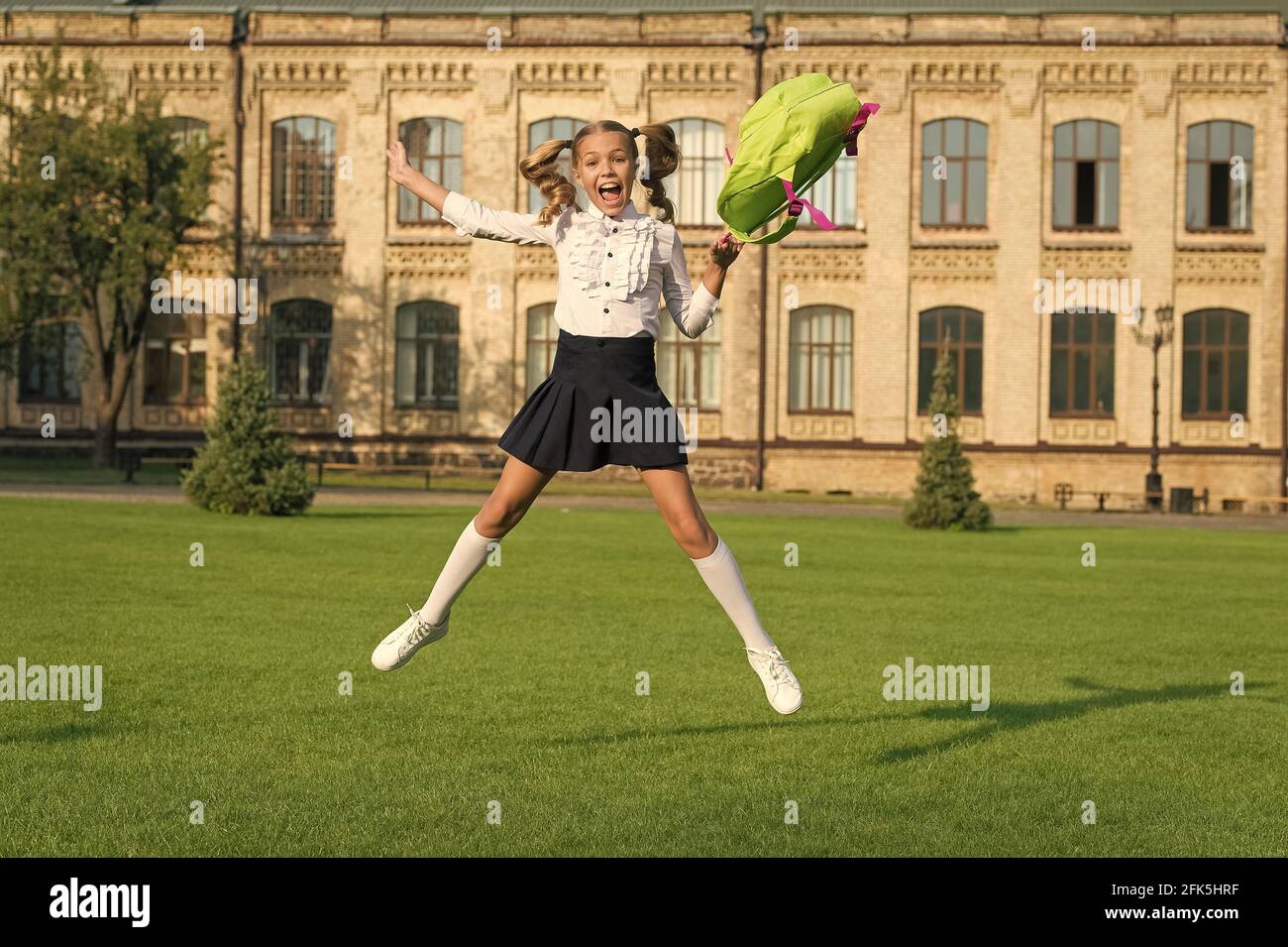 happy preschool girl with backpack. jumping in school yard. back to ...