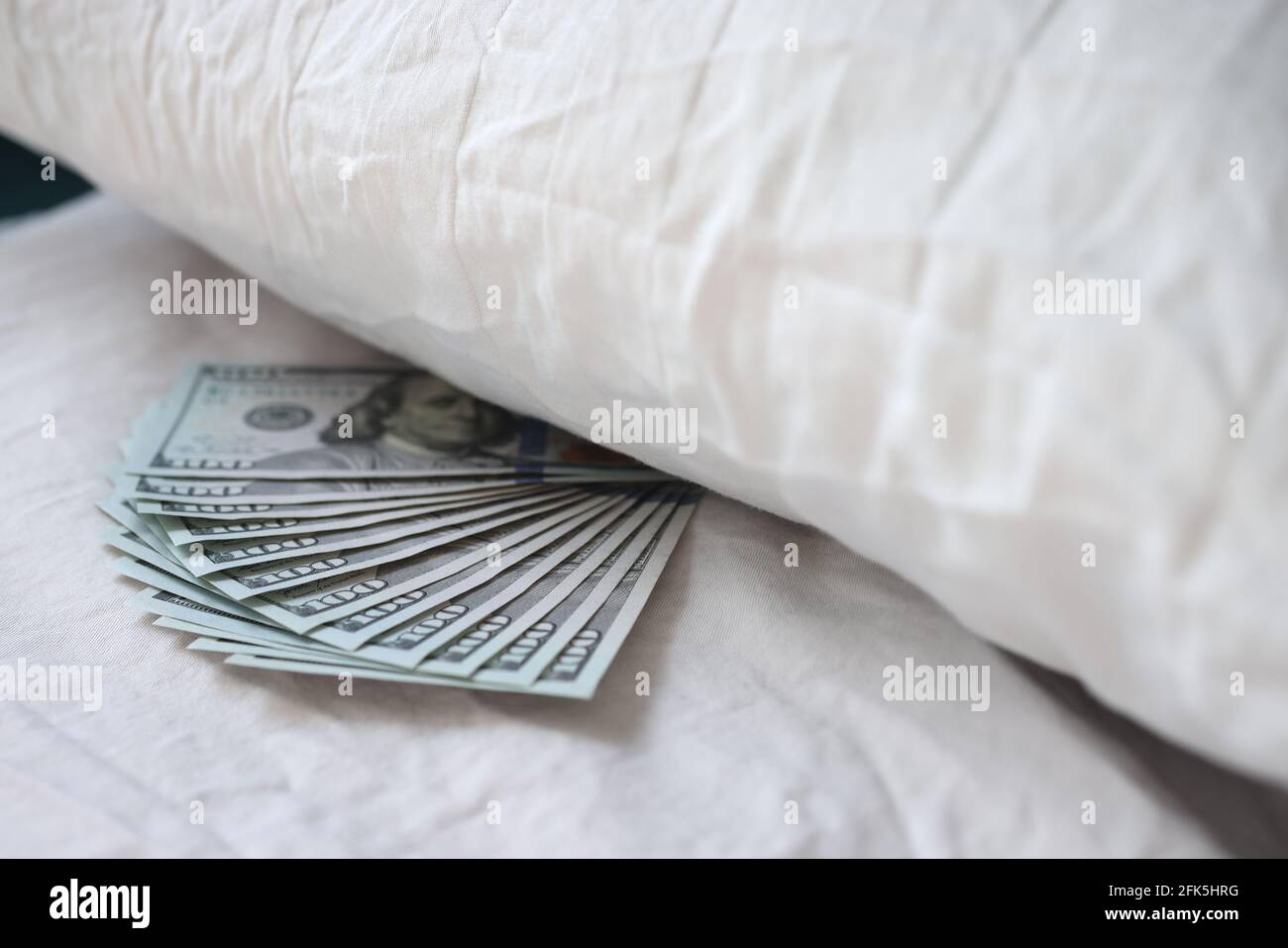Lot of american dollars lying under pillow in bedroom closeup Stock Photo