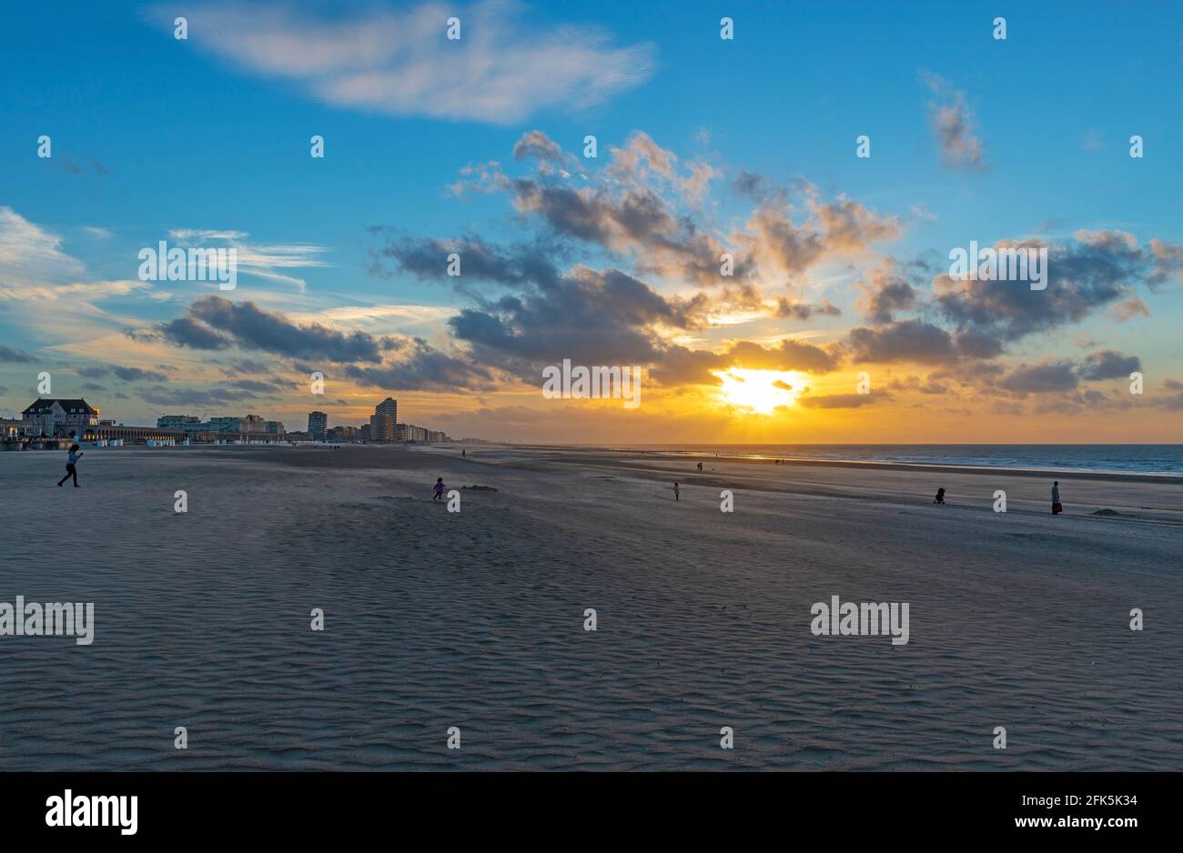 Silhouette of unrecognizable people walking on Oostende (Ostend) beach at sunset, Flanders, Belgium. Stock Photo
