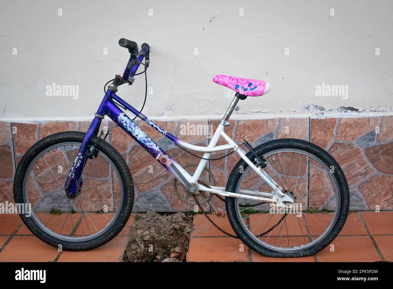 Guatapé, Antioquia, Colombia - April 3 2021: Old Bicycle with Flat Tire is Leaning Against a House Wall Stock Photo