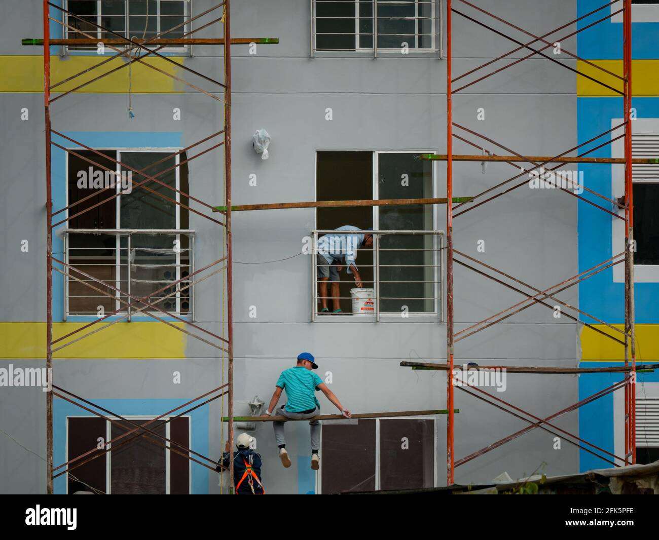 Guatapé, Antioquia, Colombia - April 4 2021: Men at Work Painting a
