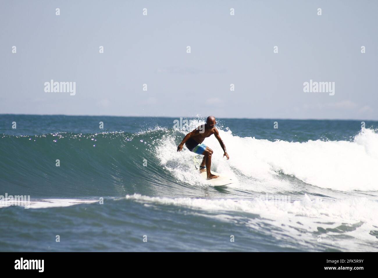 Spanish male catching the wave on a surfboard Stock Photo Alamy