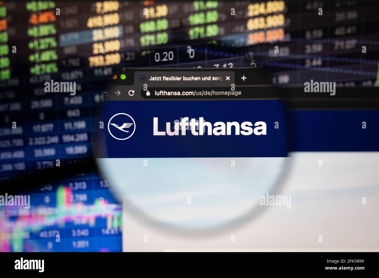 Lufthansa company logo on a website with blurry stock market developments in the background, seen on a computer screen through a magnifying glass Stock Photo