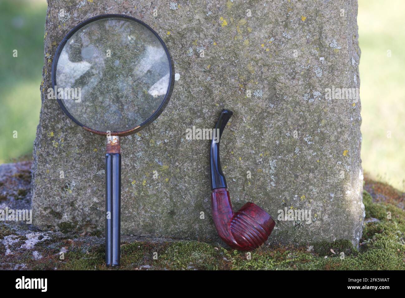 magnifying glass and pipe on the grave of Sir Arthur Conan Doyle in All Saints Churchyard, Minstead, New Forest District, Hampshire, England Stock Photo