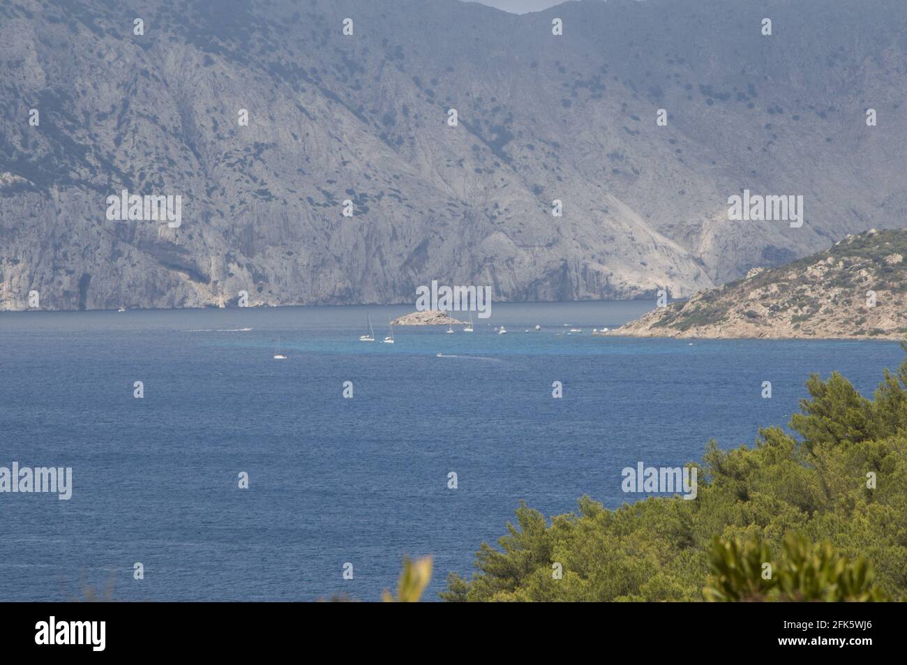 High angle shot of a lake surrounded by mountains and green trees on ...