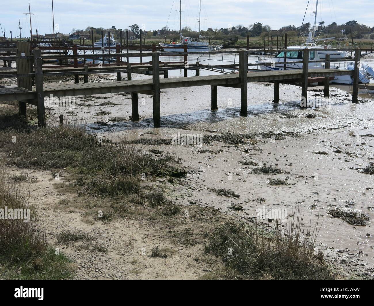 Wooden landing stages extending across the muddy banks of the River Blyth: Southwold Harbour in eastern Suffolk, April 2021. Stock Photo