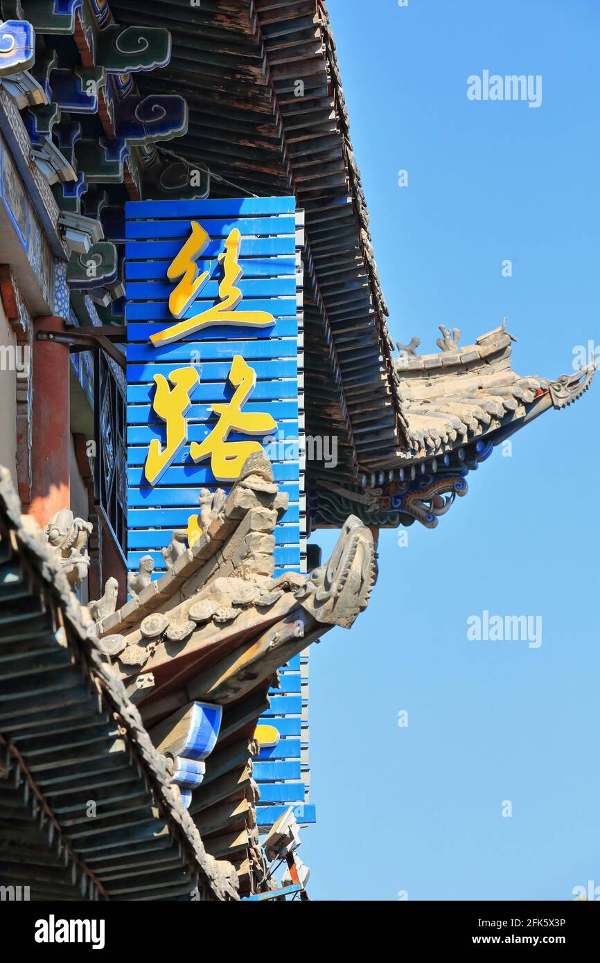 Yellow Chinese writing-blue signboard of restaurant. Ming Qing food street-Zhangye-Gansu-China-1300 Stock Photo