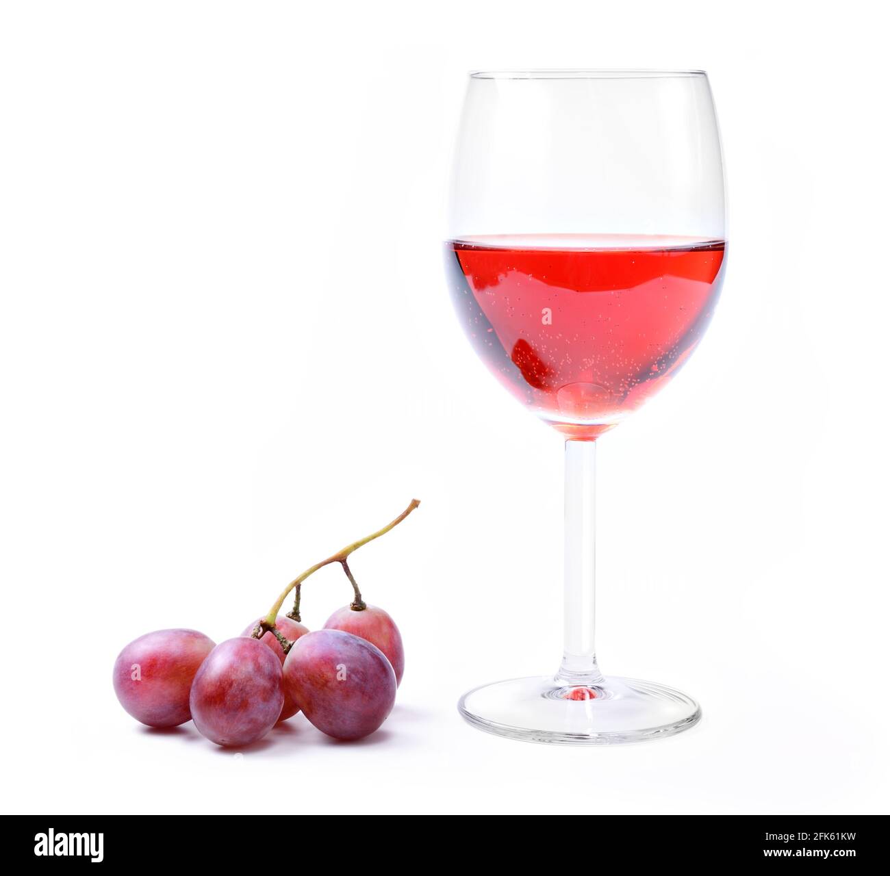 Glass of rosé wine with small bunch of grapes isolated on white background, closeup. Stock Photo