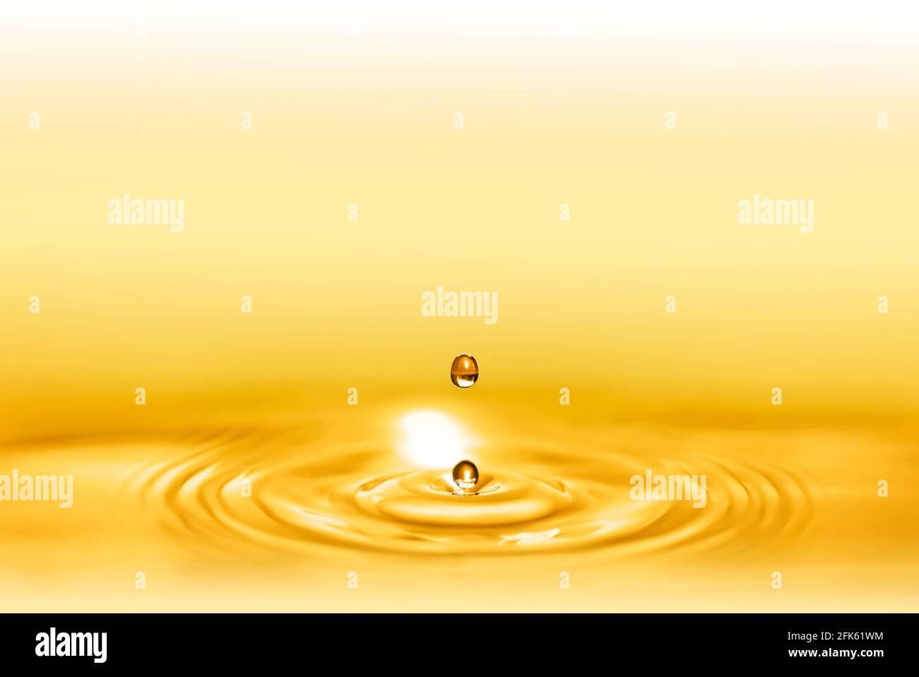 Macro shot of droplets splash of a golden elixir for beauty and body ...