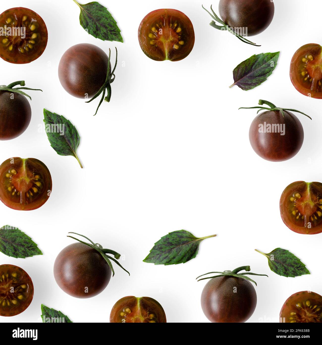 Kumato cherry tomatoes with basil leaves on white background Stock