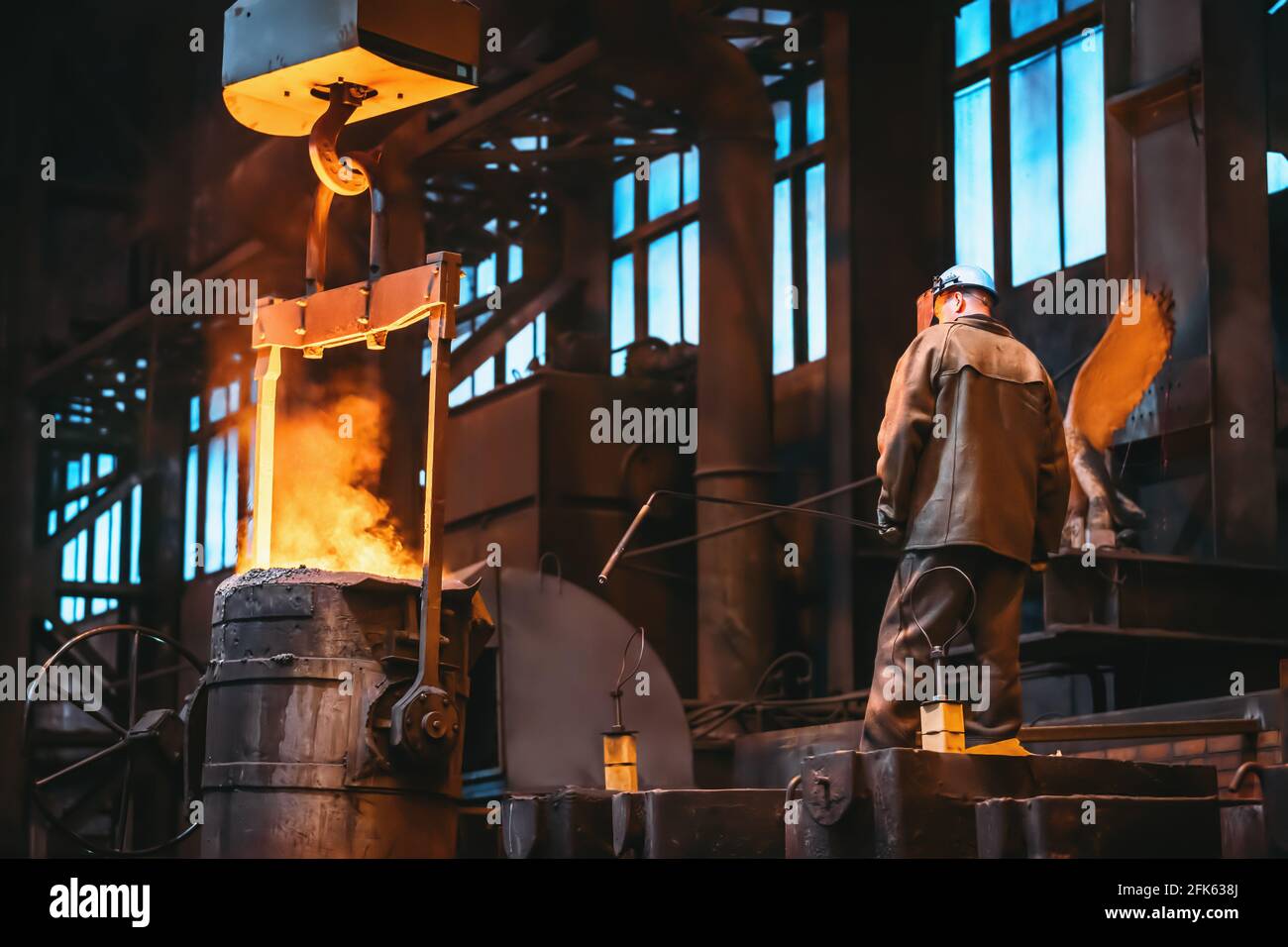Metallurgist control casting metal in foundry workshop factory. Stock Photo
