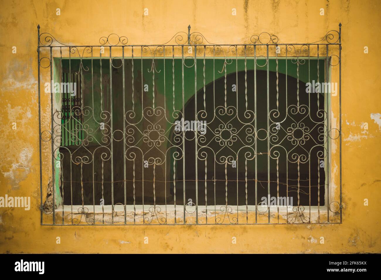 Wrought Iron, yellow facade from a house in Izamal, Yucatan, Mexico. Stock Photo