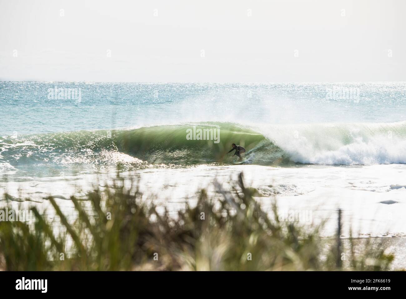 Athletic Man getting barreled in big summer hurricane waves Stock Photo