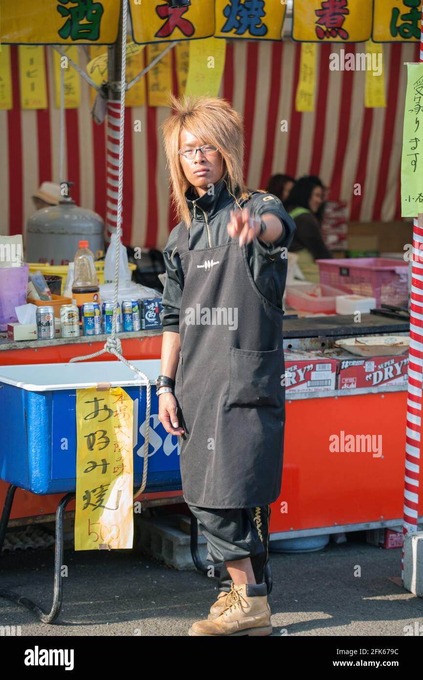 Japanese male gyaruo with deep suntan working on food stall at Yasukini Shrine, Tokyo, Japan Stock Photo