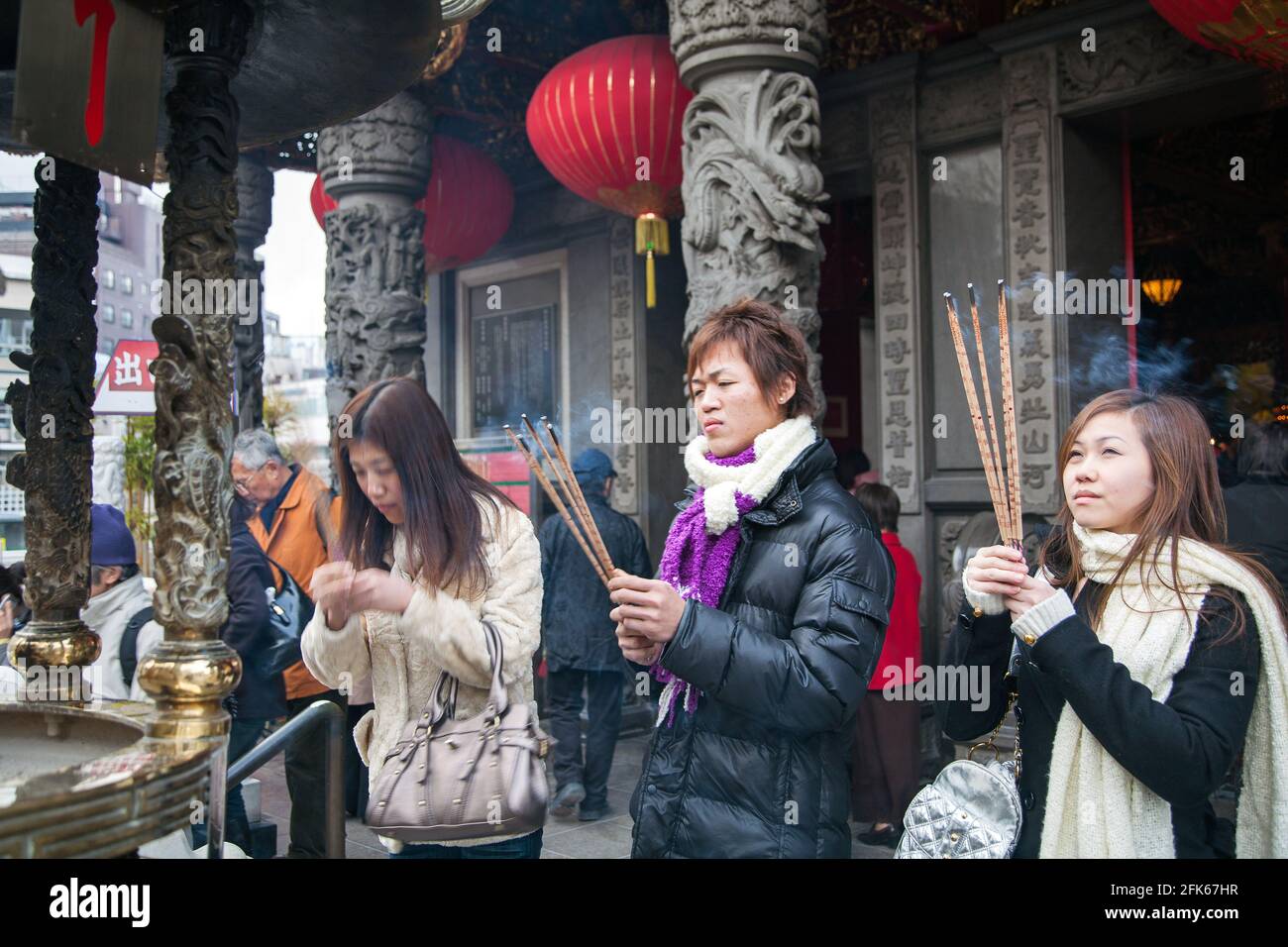 Japanese females burning incense sticks whilst praying at Kanteibyo Temple, Chinatown, Yokohama, Japan Stock Photo