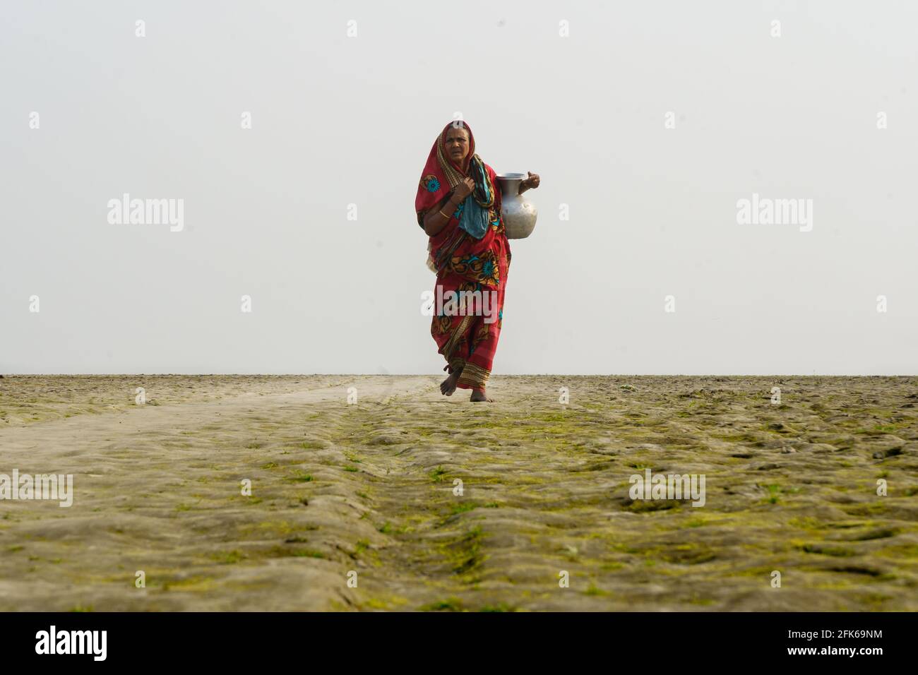 Manikganj, Bangladesh. 24th Feb, 2021. Due to arsenic problems in tube well water, people on the bank of the river 'Padma', travels about two or three kilometers to collect arsenic-free water. (Photo by Sushanta Paul/Pacific Press) Credit: Pacific Press Media Production Corp./Alamy Live News Stock Photo