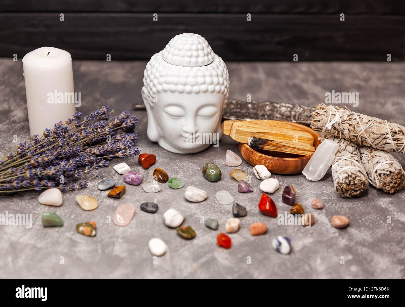 Spiritual ritual meditation face of Buddha, candles on grey background