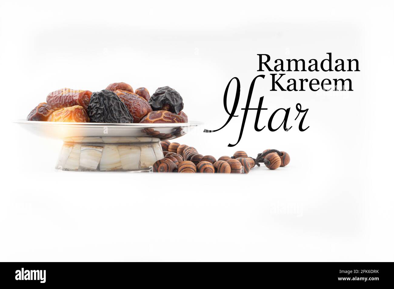 RAMADAN KAREEM IFTAR text with Dates or kurma fruits and rosary beads or Tasbih on white background. Ramadan Kareem and Islamic Concept Stock Photo