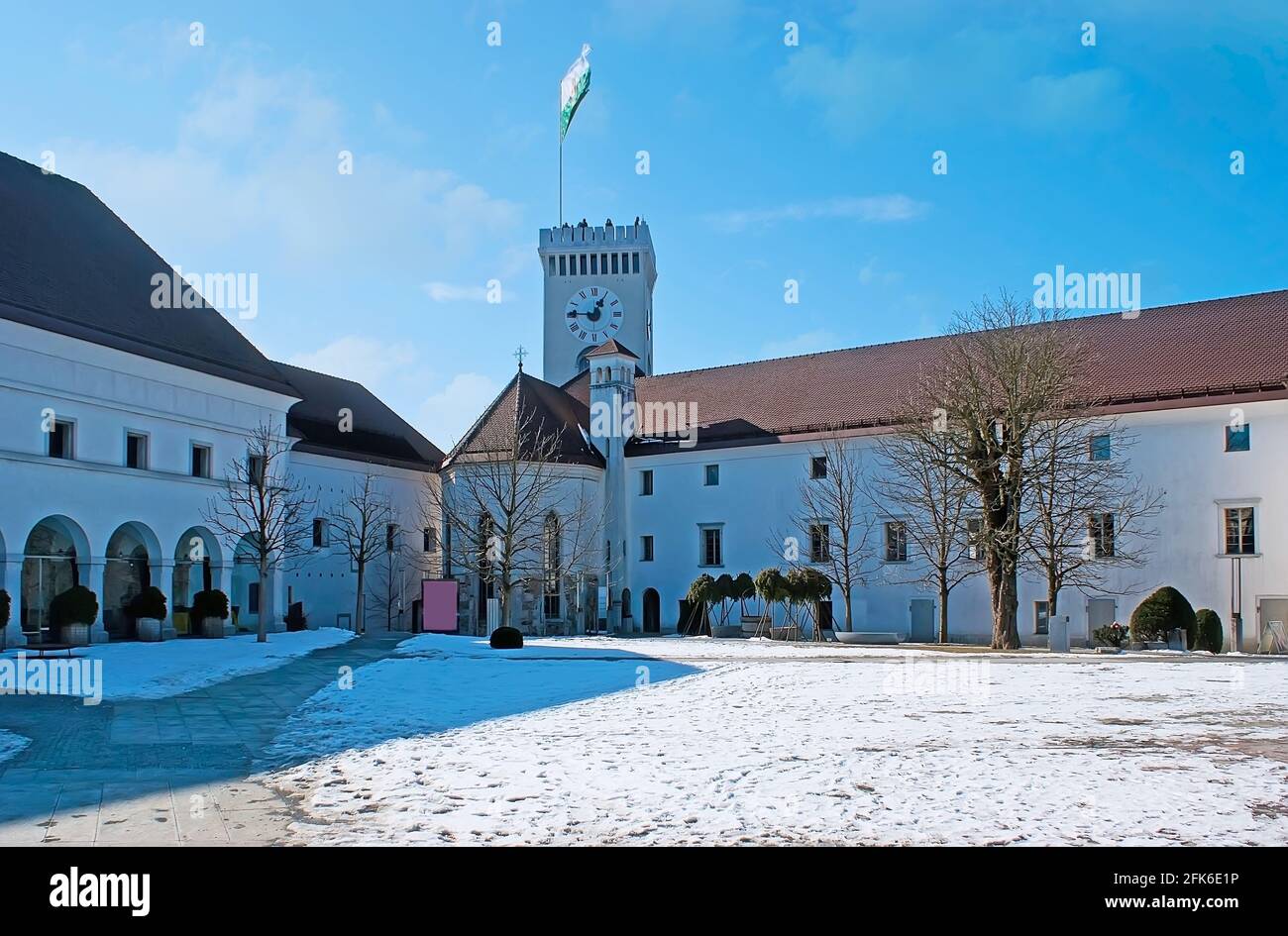 The snowy courtyard of Ljubljana Castle (Ljubljanski Grad) with histroic buildings of St George Chapel and the Panoramic Tower, Slovenia Stock Photo